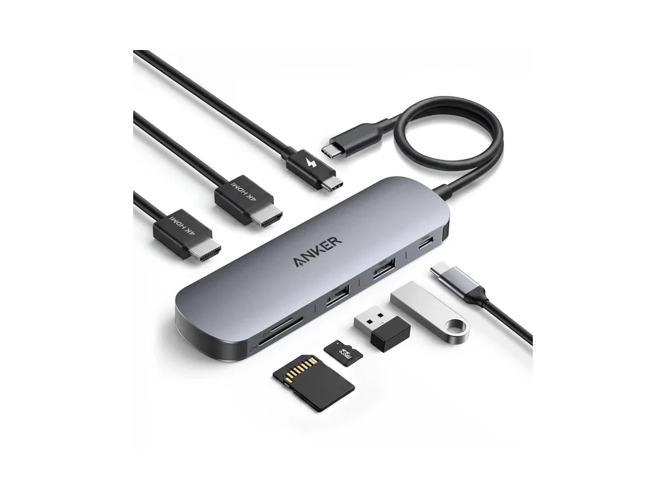 Grey Anker Nano USB-C hub with HDMI and USB cables, a USB stick and memory cards around it, on a white background