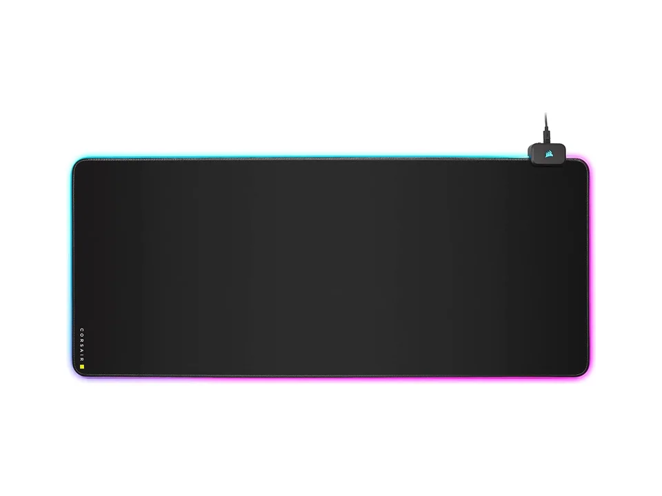 Black Corsair MM700 RGB Extended desk mat with a thin lit edge and its USB hub in the corner, on a white background