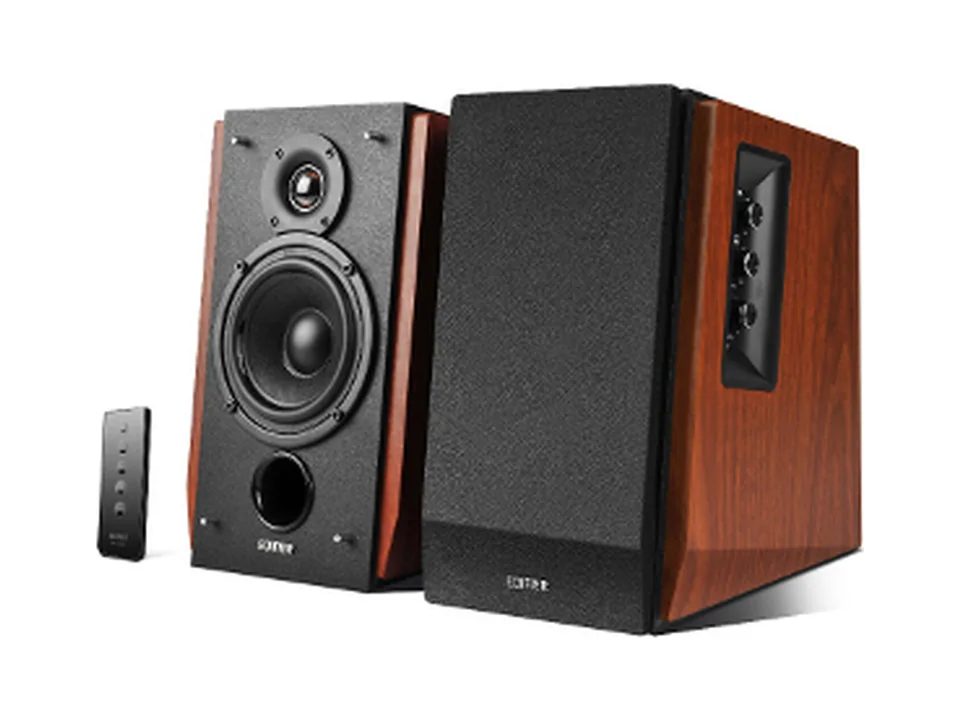 Pair of Edifier R1700BT bookshelf speakers with wood sides, one without its grille, next to the remote