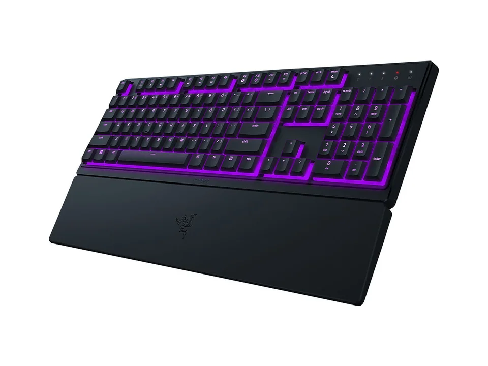 Clavier Razer Ornata V3 X noir avec éclairage violet et son repose-poignet, vu de trois quarts sur fond blanc