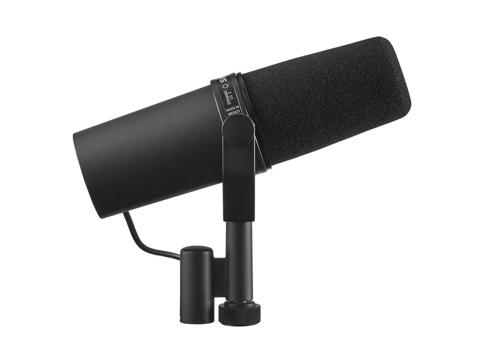 Black Shure SM7B microphone with foam windscreen on its yoke mount, side view