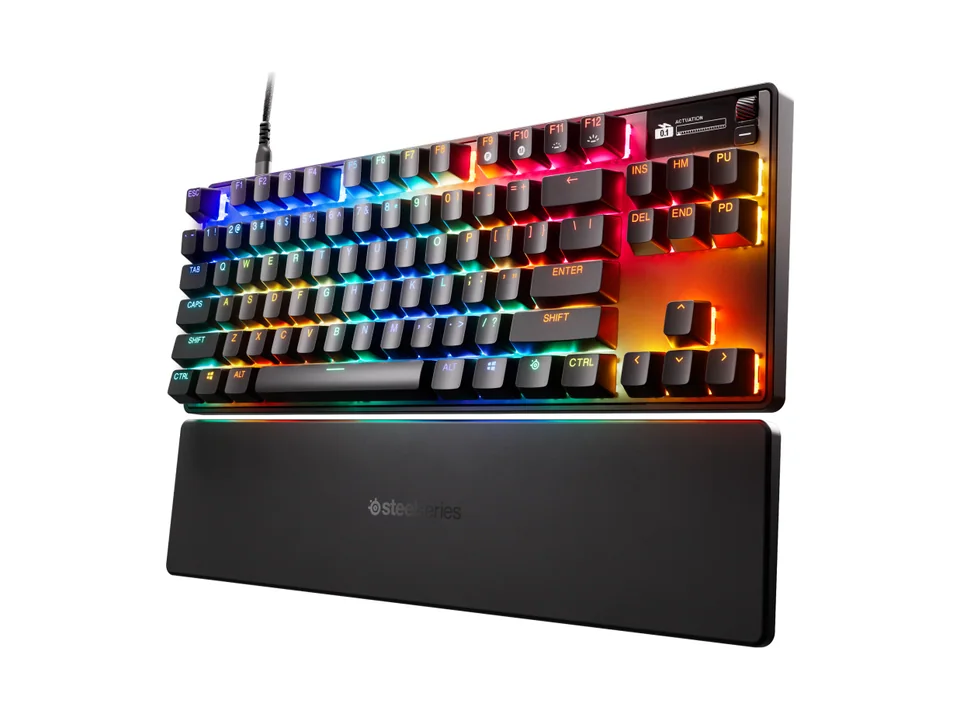 SteelSeries Apex Pro TKL Gen 3 keyboard with rainbow RGB lighting and its wrist rest, three-quarter view on a transparent background